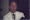 Film still of a man wearing a tie and white doctor's coat.