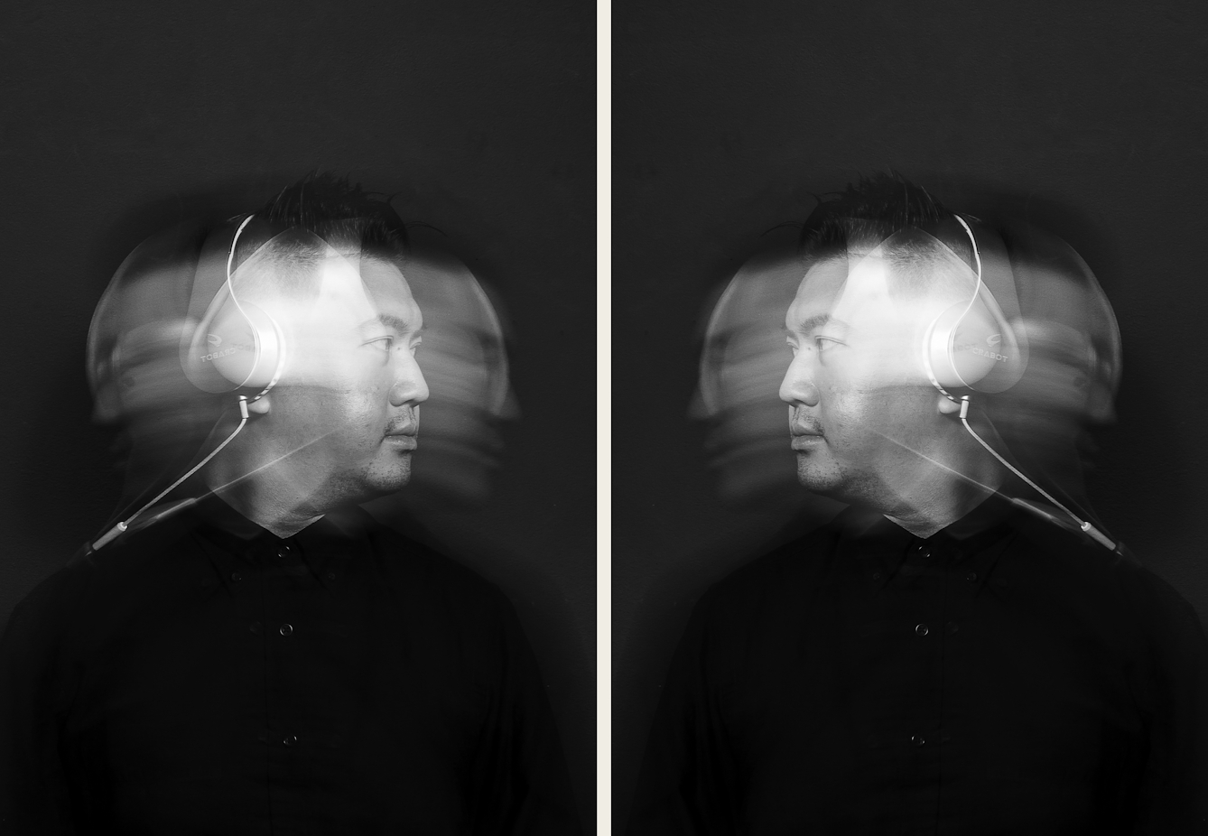 Photographic diptych showing on the left, a black and white photographic portrait of a man dressed in a black shirt wearing a pair of over ear headphone with the white cables trailing over his shoulder. He is pictured from the chest up. The man's face is spotlit in a small circle of light. He is standing against a black background which means he is surrounded by darkness. He is moving his head from side to side causing his head to motion blur in an arc across the image. A flash light has caught this head as it is turned to the right, creating a sharp image within the blur. The image on the right is a mirror image of the image not he left so the two frozen faces are looking at each other.