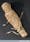 Photograph of a mummified infant. Top three quarter view. Black background.