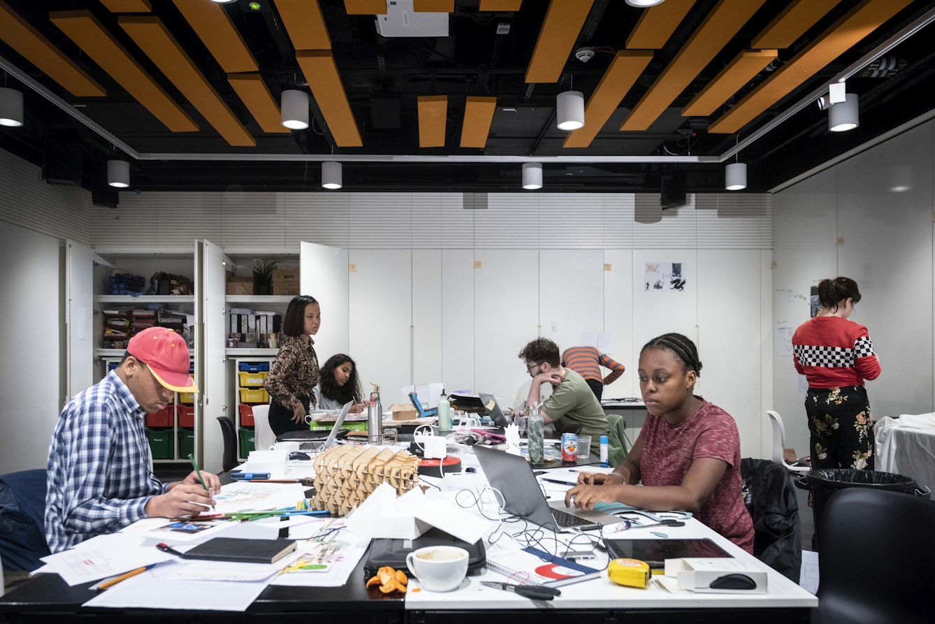 Seven young people working around a big table in the Studio