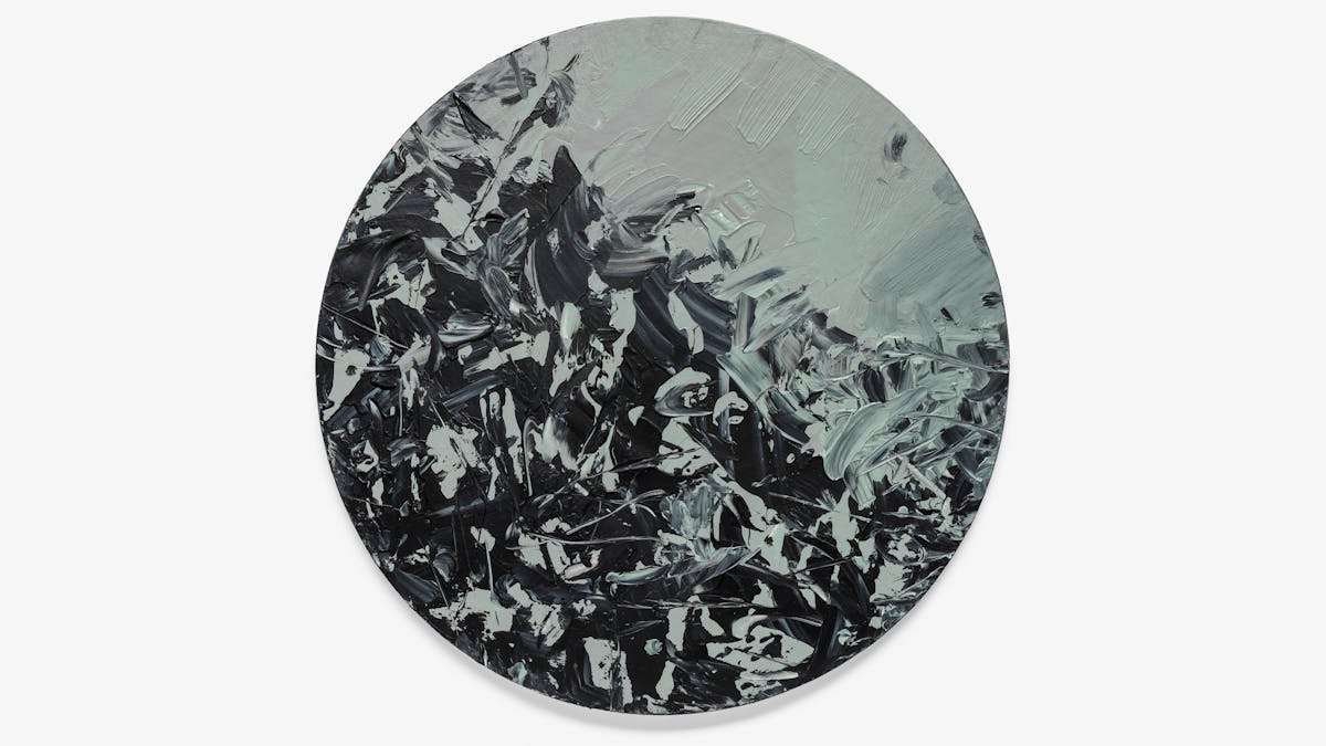 Photograph of an abstract expressionist painting on a large circular canvas, titled 'Binaries'. It is predominantly monochrome. The background layer is completely covered with grey and green-grey hues. Textural qualities have been captured in the acrylic paint including impressions made by deep brush strokes and gathered, layered paint. Black expressionist marks, created with a palette knife, scatter across the surface and begin to accumulate towards one side of the canvas. Some marks include waves of banded black and grey. The black marks are reminiscent of a murder of crows, with their onyx wings stretching and taking flight. The artwork rests on a light grey background with a small shadow on the lower half which reveals its three dimensional physicality.