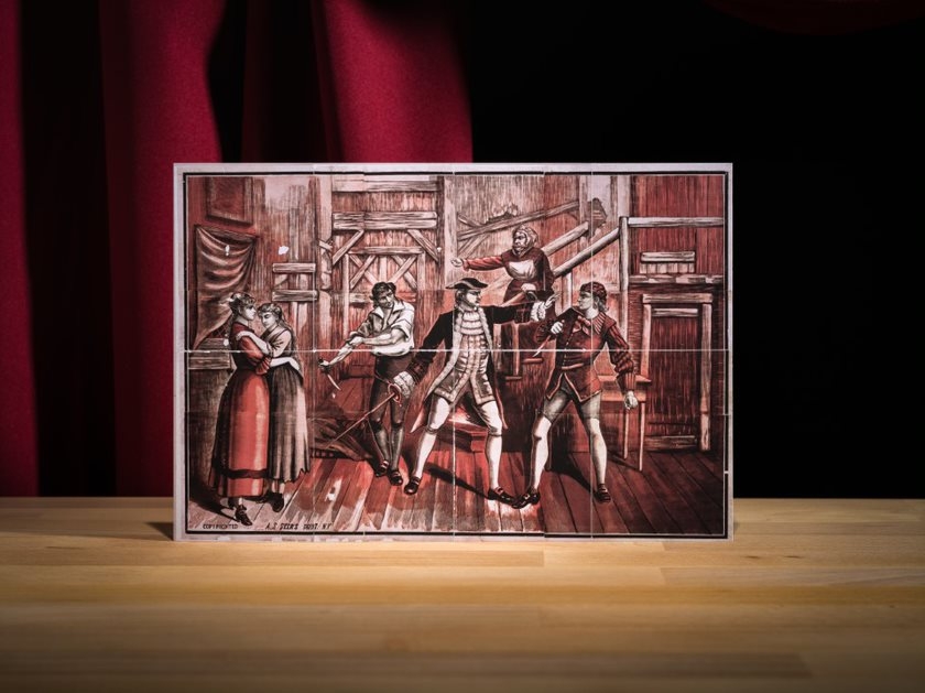 Coloured performing arts poster showing three men fighting with daggers & a sword while two women stand to side and woman gestures from stair. 