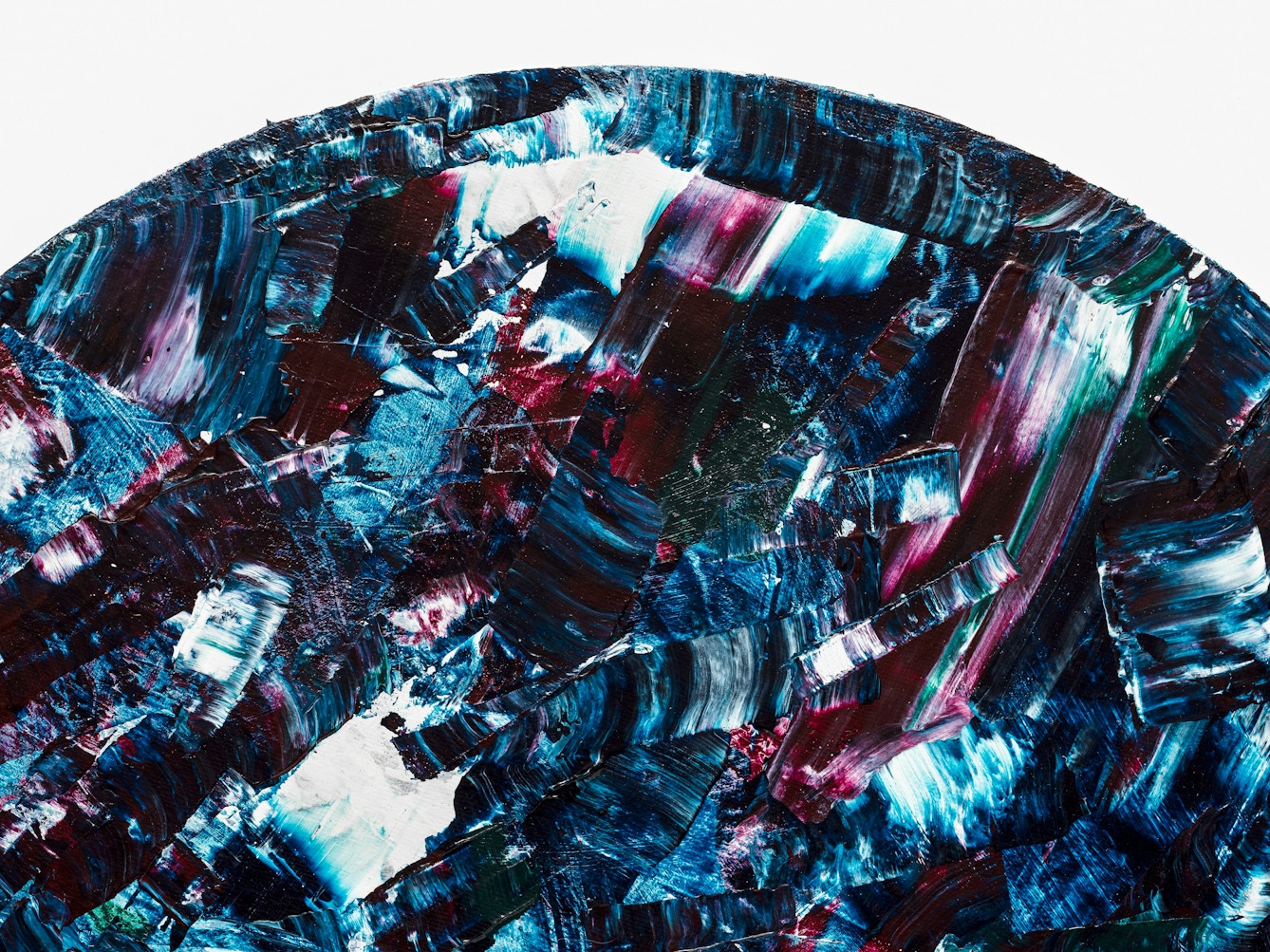 Detail from a larger abstract expressionist painting utilising acrylic paint on a circular canvas, titled 'Dissonant'. This detail reveals the top curve of the circular canvas. The vast majority of the canvas surface contains sharp disconnected marks of blues, purples, turquoise, white and scarlet. The marks are short and random in direction and length. Together they make up a scene of fractured and abrupt expression, yet with a compelling beauty.
