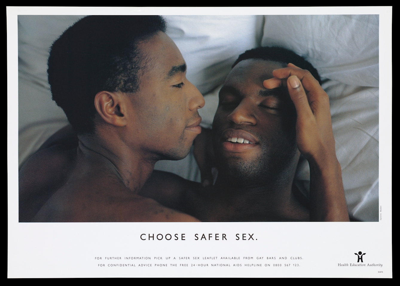 A photograph of two gay black men laying in bed with the headline 'Choose safer sex'.