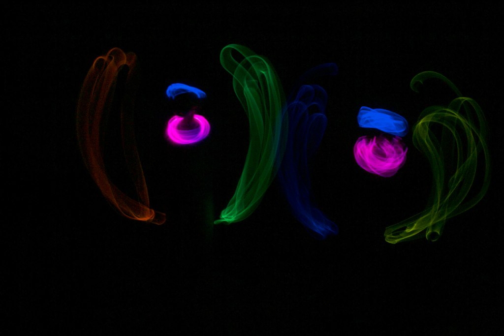 Swirls of red, blue, pink, green and yellow against a black background