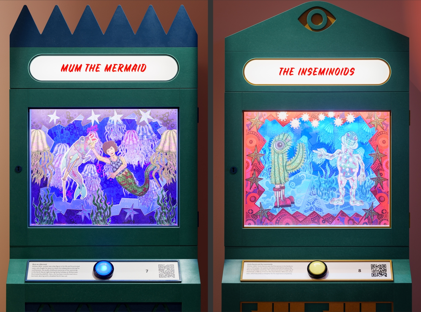 Diptych of two exhibition exhibits. The exhibits resemble an arcade machine with a large button on the front and a large glass fronted diorama, inside which are multi-layered theatre style scenes containing colourful drawings of characters and scenery. The exhibit on the left has the backlit title, 'Mum the Mermaid' and on he right, 'The Inseminoids'.