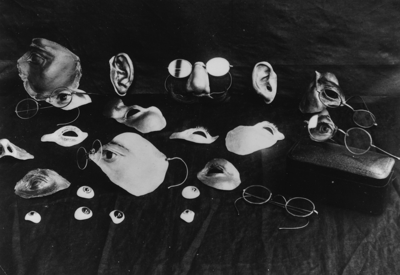 A selection of items used to conceal facial injuries during the early development of plastic surgery, 3rd London General Hospital. Included are eyes, ears, noses, and parts of the face, as well as several pairs of spectacles, which were used to disguise the joins and keep parts in place.