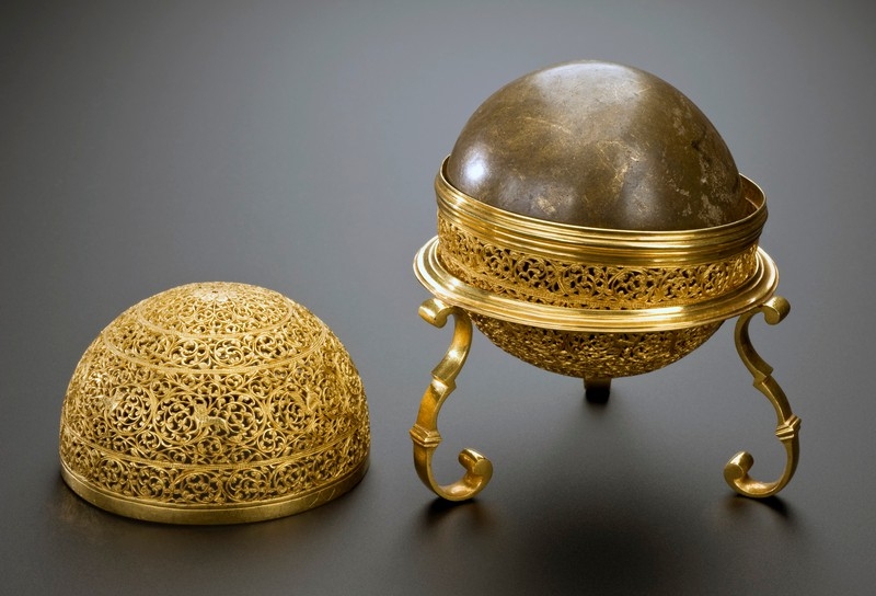 Image of gold round casket with ornate filigree