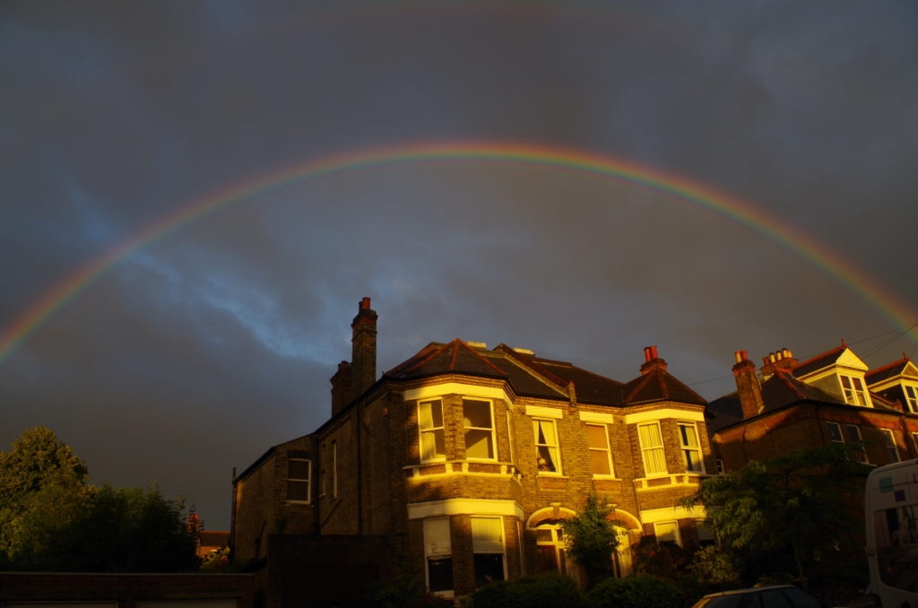 A photograph showing a rainbow arching over the top of a semi-detached house in Beckenham, London.