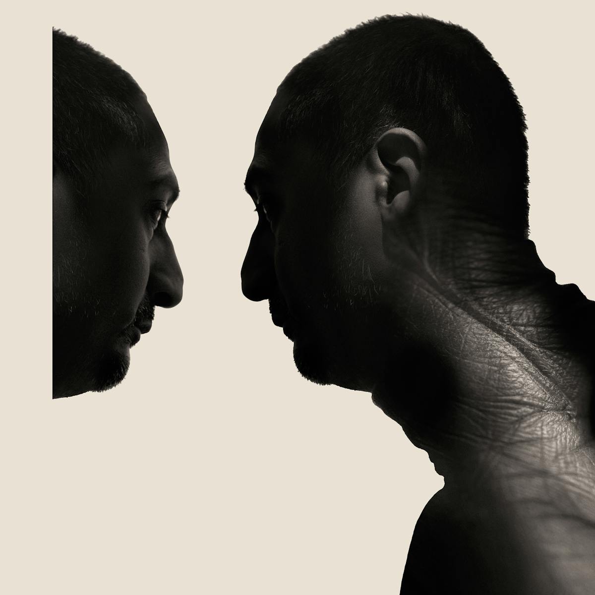 Photographic portrait of a man's head and shoulders in profile, looking to the left. He is pictured in silhouette against a cream background. Overlaid onto his neck and shoulders is an image of a scar, showing the texture of the skin and the scar tissue. The man's face is looking at a reflection of himself as if in a mirror although his reflection is cut off so only half of this head can be seen.