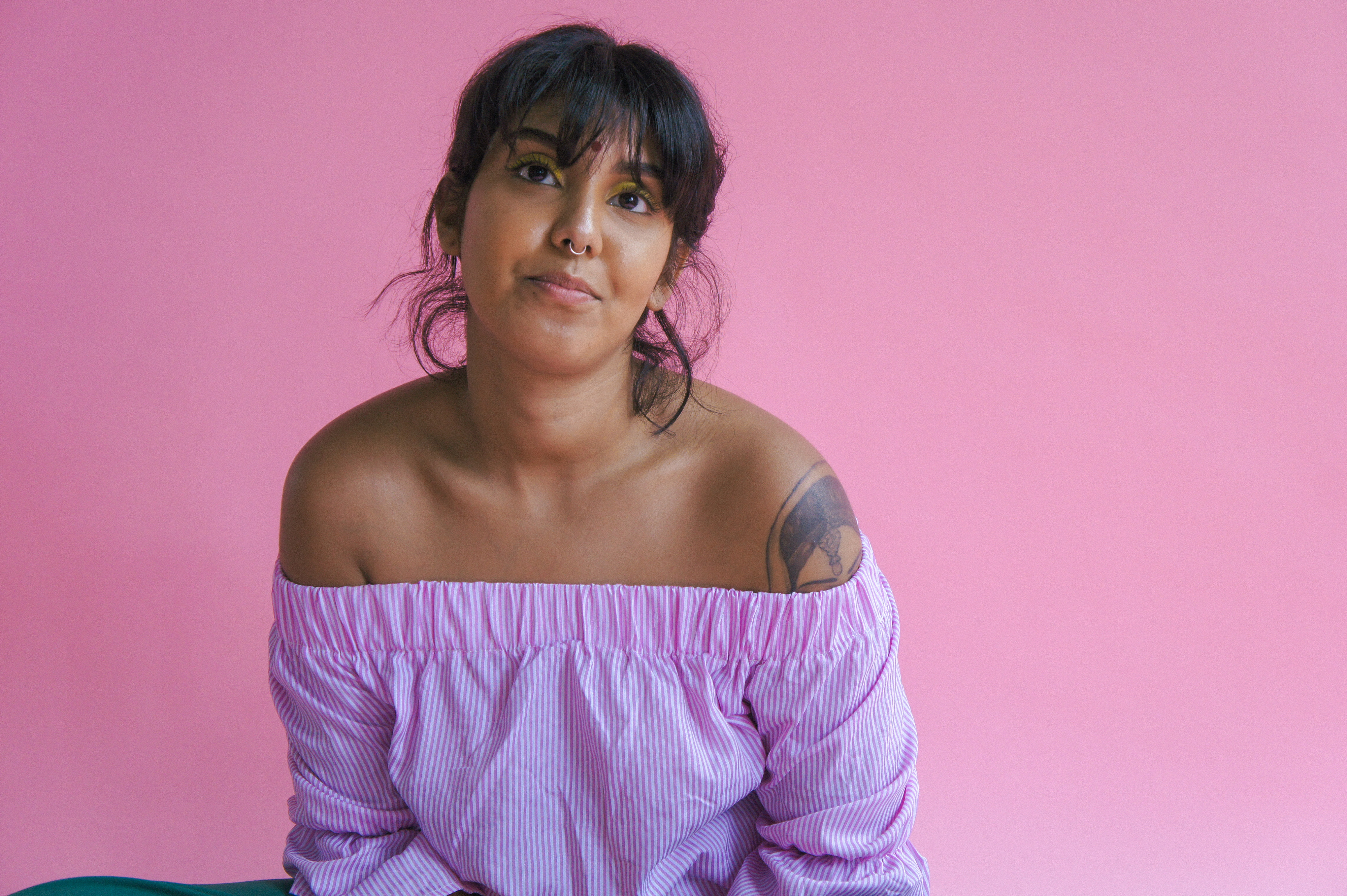 Portrait of Demi Nandhra on a pink background.