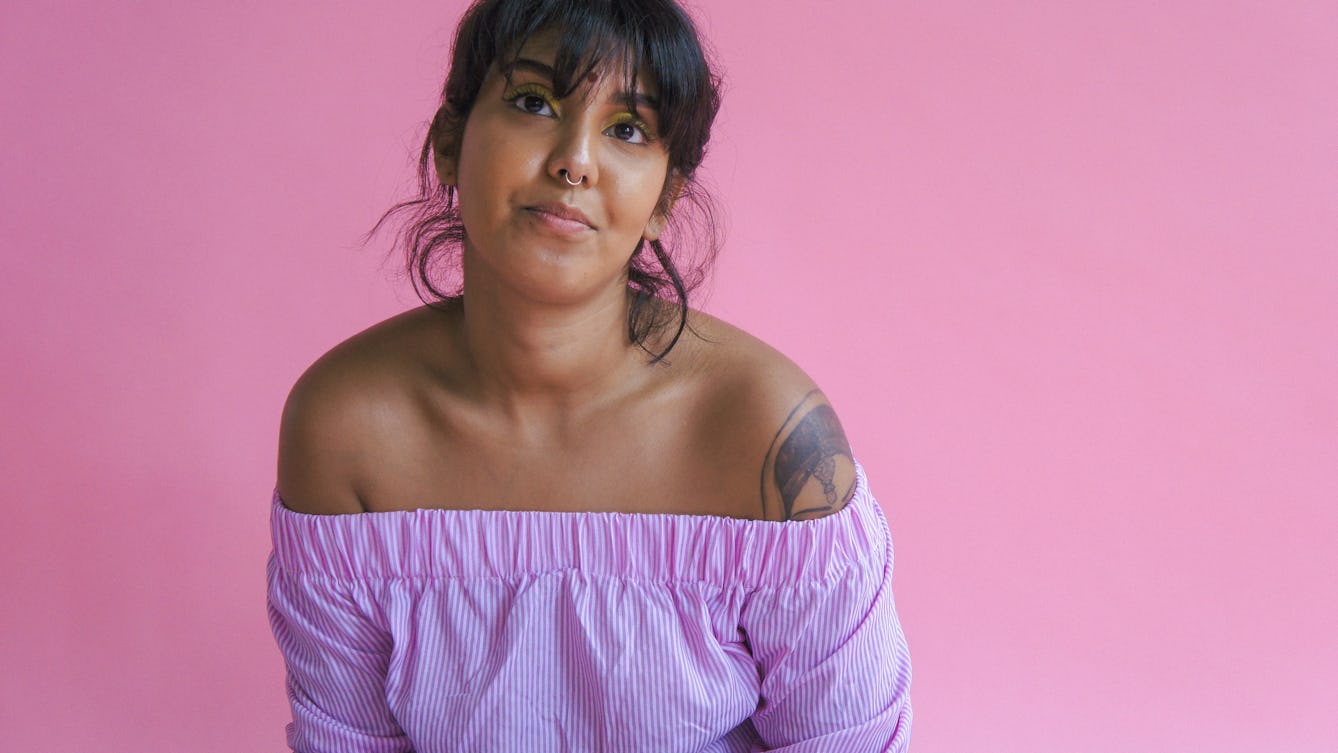 Portrait of Demi Nandhra on a pink background.