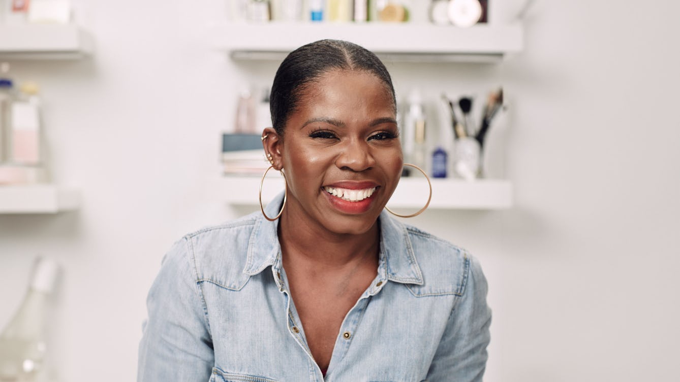 Headshot of Funmi Fetto who is smiling and wearing a denim shirt. 