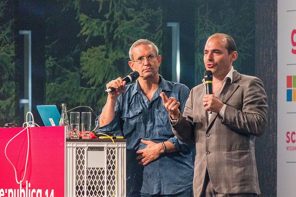 Photo of two men with microphones talking at an event