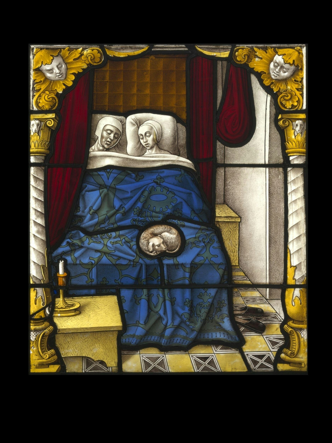 Image of a stained glass panel depicting a man and a woman in bed. They lie sleeping, with night caps on, in their bed which is covered with a deep blue brocaded bed spread. Behind them is a red curtain. On their bed is a small dog asleep. A table with a candlestick and candle is in the front left of the panel and a single pair of heeless shoes lie on the floor to the right.
