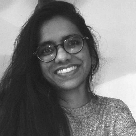 Head and shoulders photograph of a young woman with long dark hair, wearing glasses.