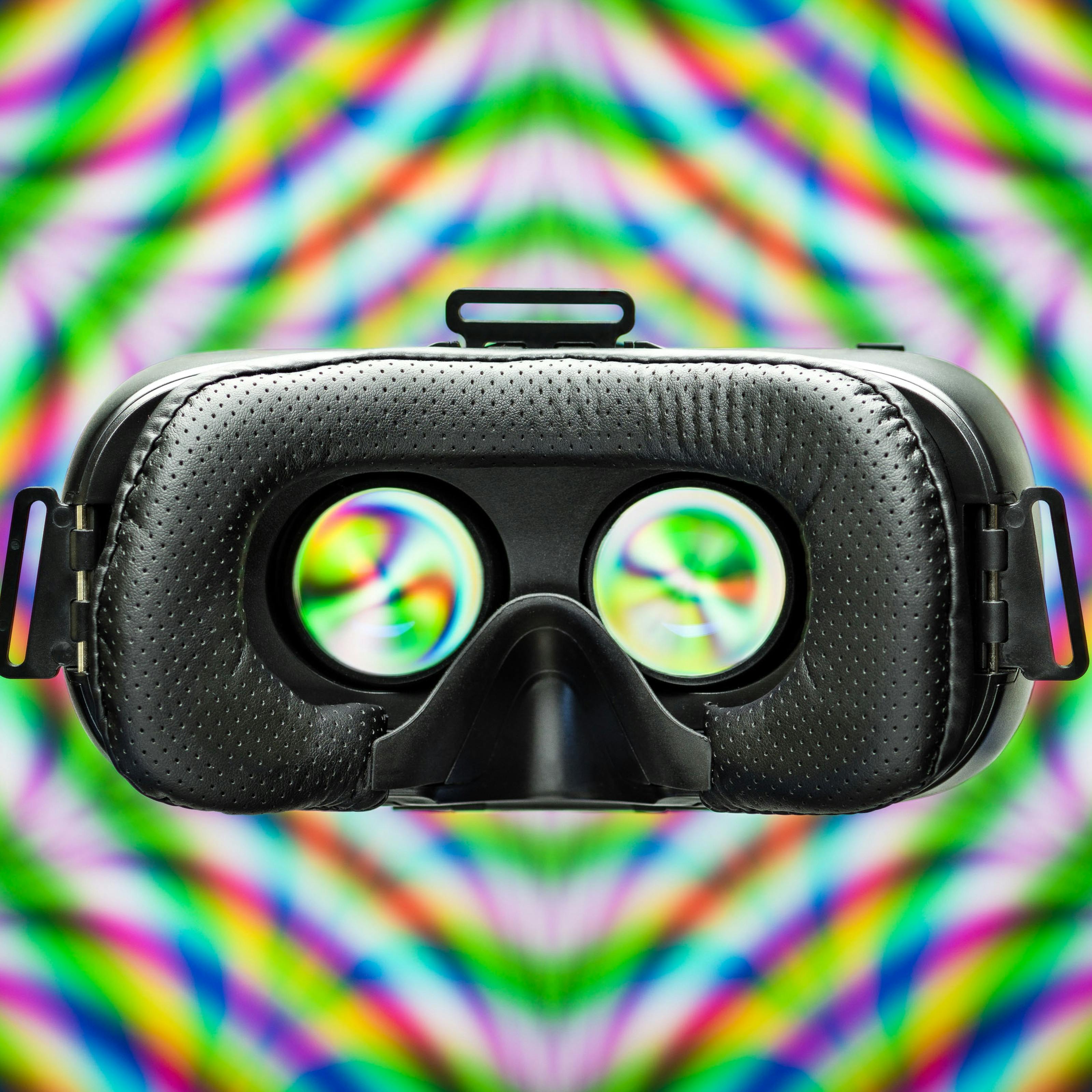 Photograph of a VR headset on a colourful patterned background.