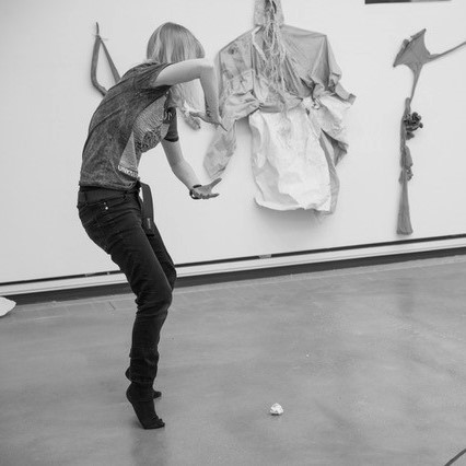 Black and white photograph of artist Sam Metz making movements with their arms and legs.