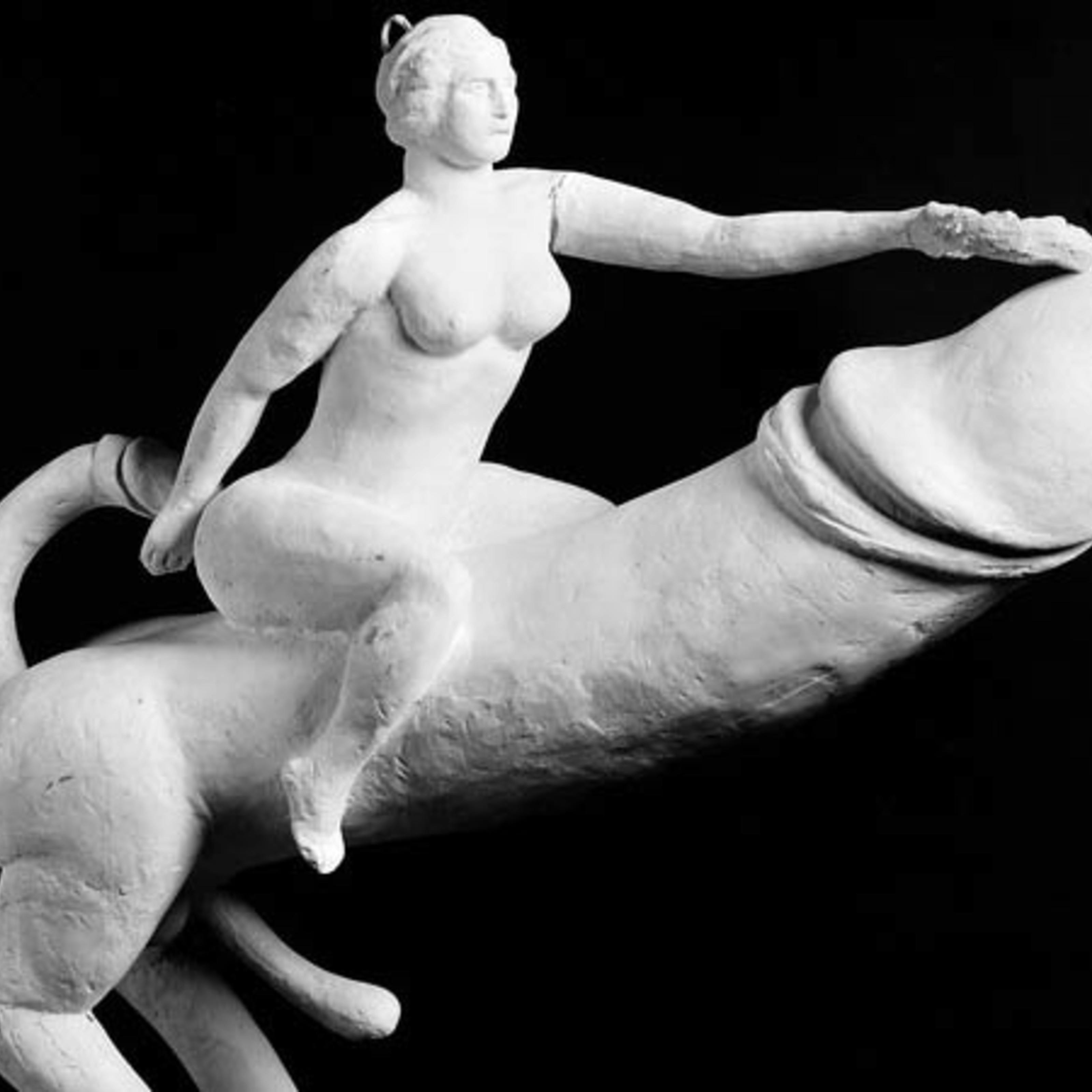 Image of a white plaster cast phallic object showing a woman astride a giant penis.