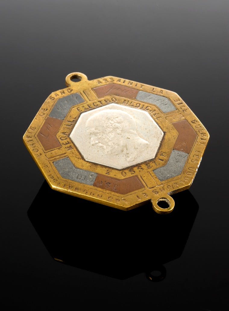 Image of octagonal shaped gold brooch with a bearded man in profile in the centre