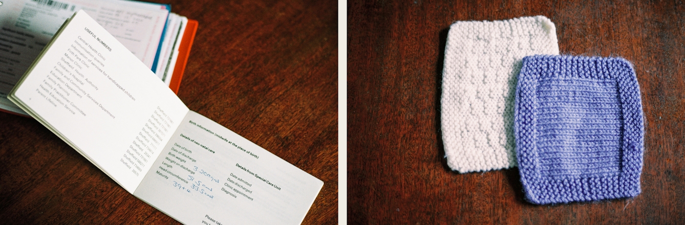 Photographic diptych. The image on the left shows an open baby record book from the 1980s resting on a dark wooden tabletop. On the open page can be seen the statistics for the new born baby, date of birth, weight and length. Behind the open book is another more modern baby record book with a red plastic cover just visible. The image on the right shows a white knitted square and a blue knitted square resting on a dark wooden tabletop. The blue square on top overlaps the white square slightly. Each square has a different pattern knitted into it.