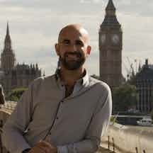 Image of Paul Steinberg leaning on a bridge in front of Big Ben.