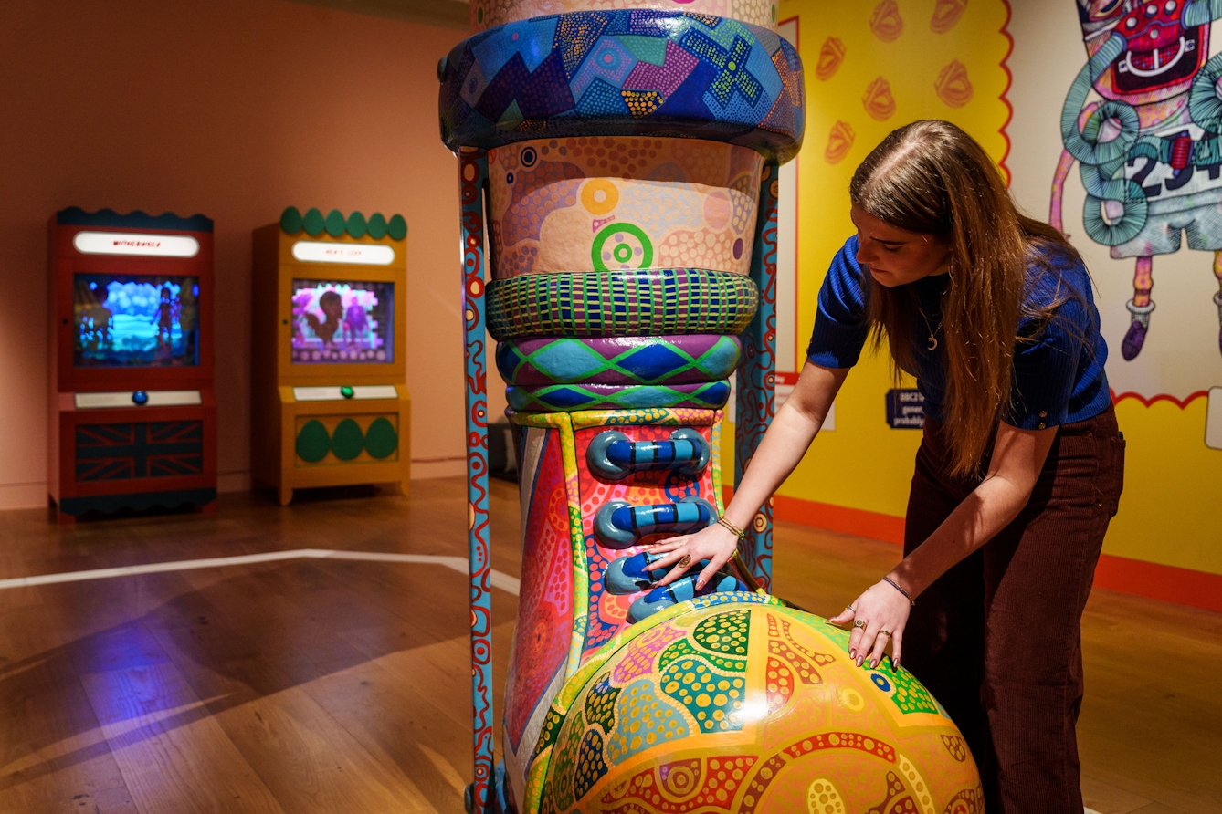 Photograph of a person touching a large sculpture in the exhibition.