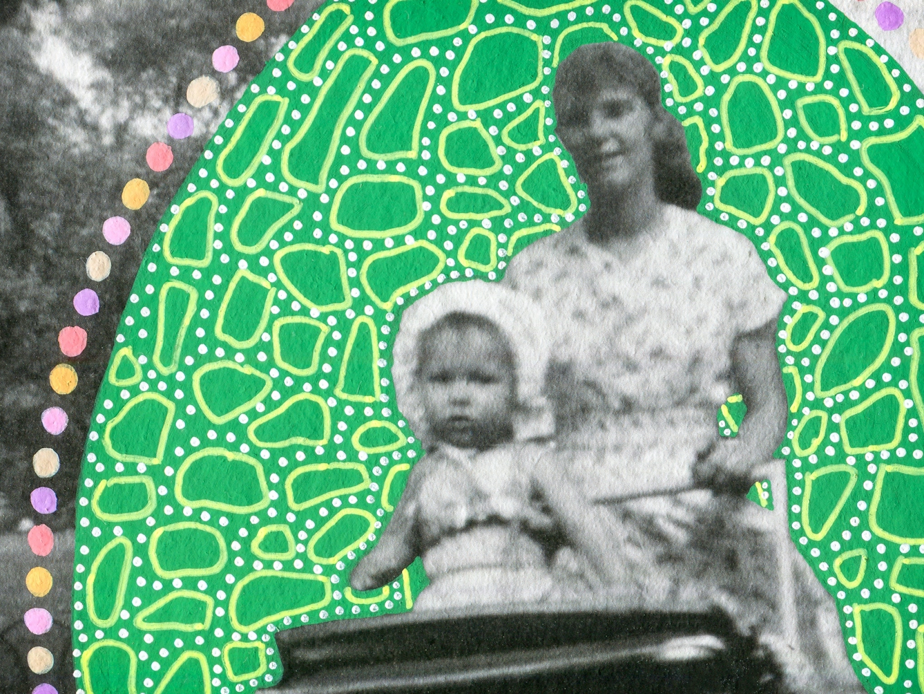 Artwork created by painting over the surface of a black and white photographic print with colourful paint. The artwork shows the original scene of a young woman walking through a parkland scene pushing a pram. Sitting up inside the pram is a young toddler facing forwards. The woman, toddler and pram are surrounded by a large oval shape painted green, which is covered in small lighter green dots and many organic shaped circular light green outlines. Around the edge of the oval shape are a line of coloured painted spots, of yellow, pink and purple. The texture of the paint can be seen on the surface of the print.
