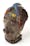 Photo of a shrunken head from Ecuador with a stitched mouth and feather headdress