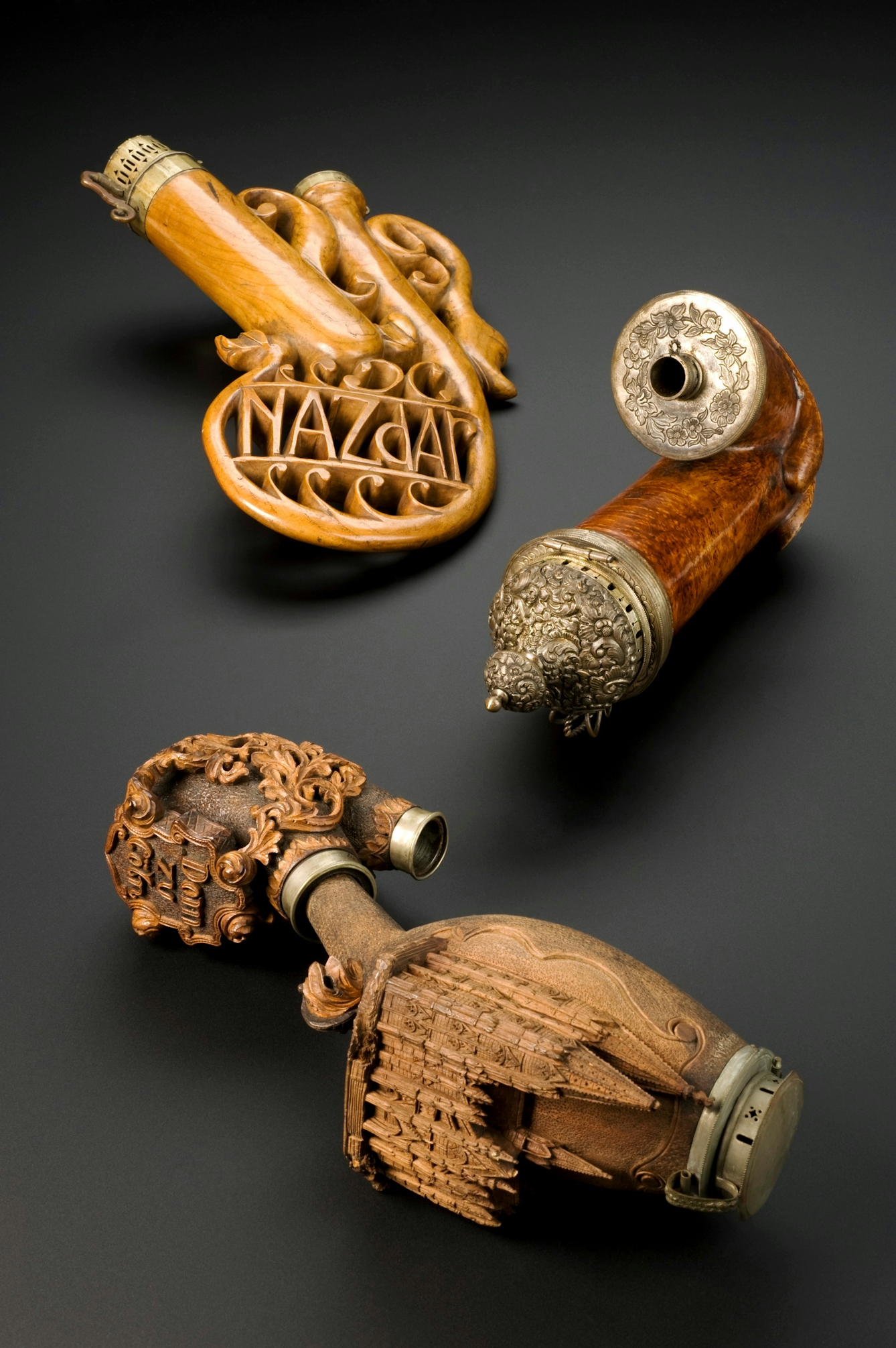 Pipes carved into a horn shape from wood, with decorative swirls and leaf-like ornamentation.