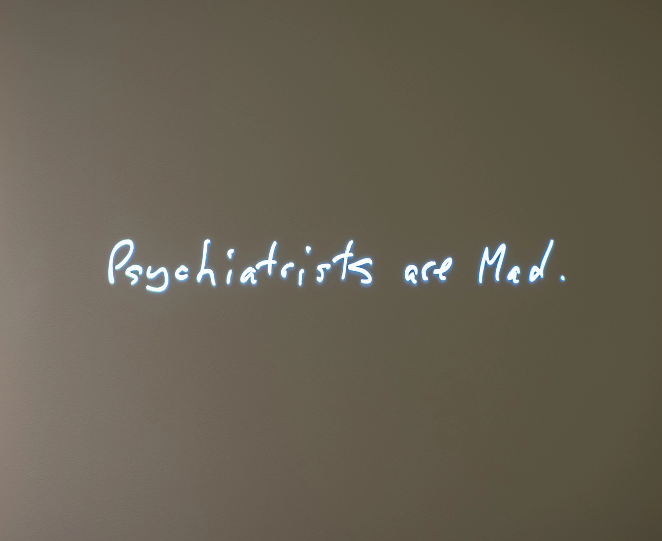 Image of a projection of a hand-painted sign called 'Psychiatrists are Mad' by Audrey Amiss.