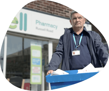 Driver carrying a box outside a Well pharmacy
