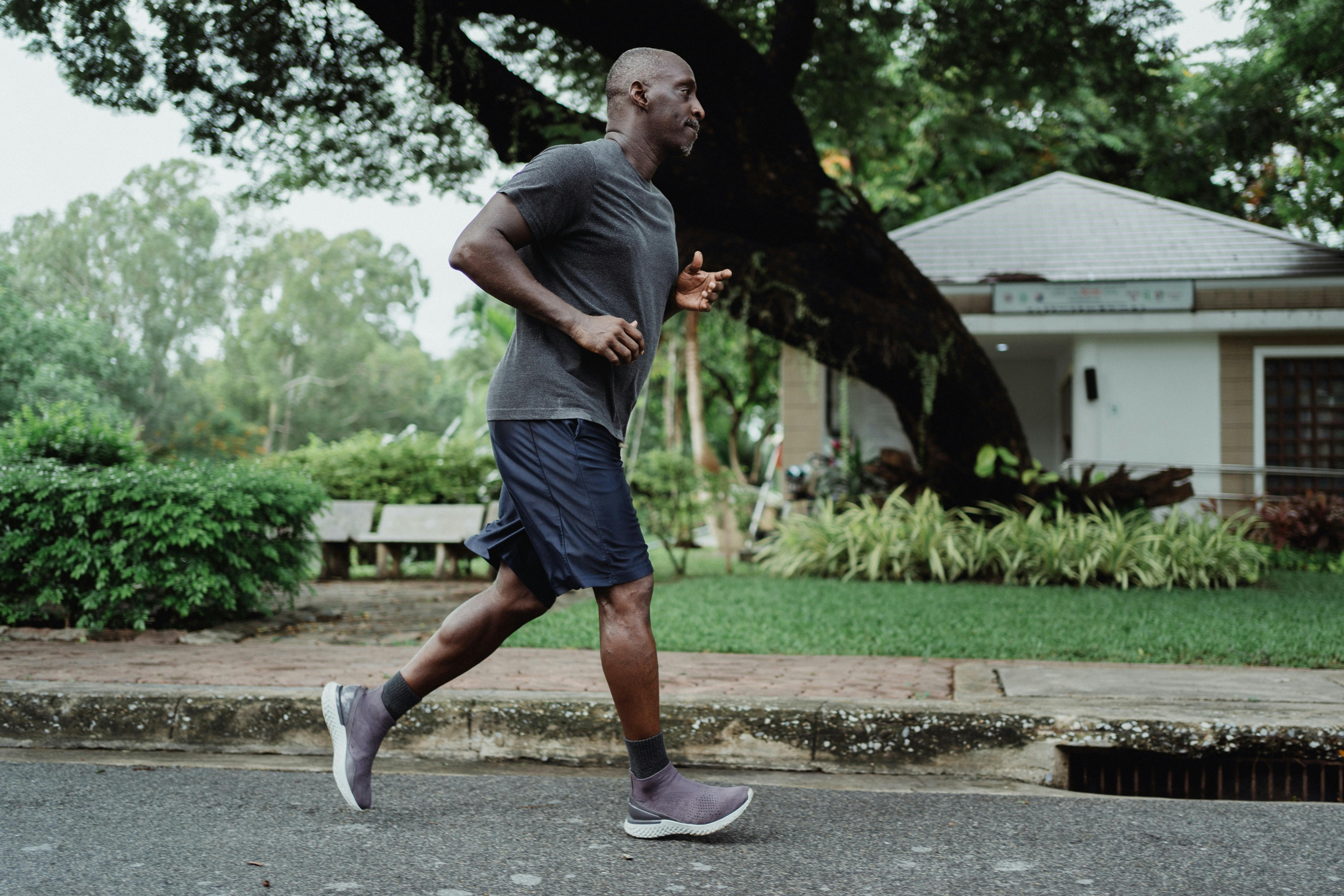 A man jogging down a residential road.