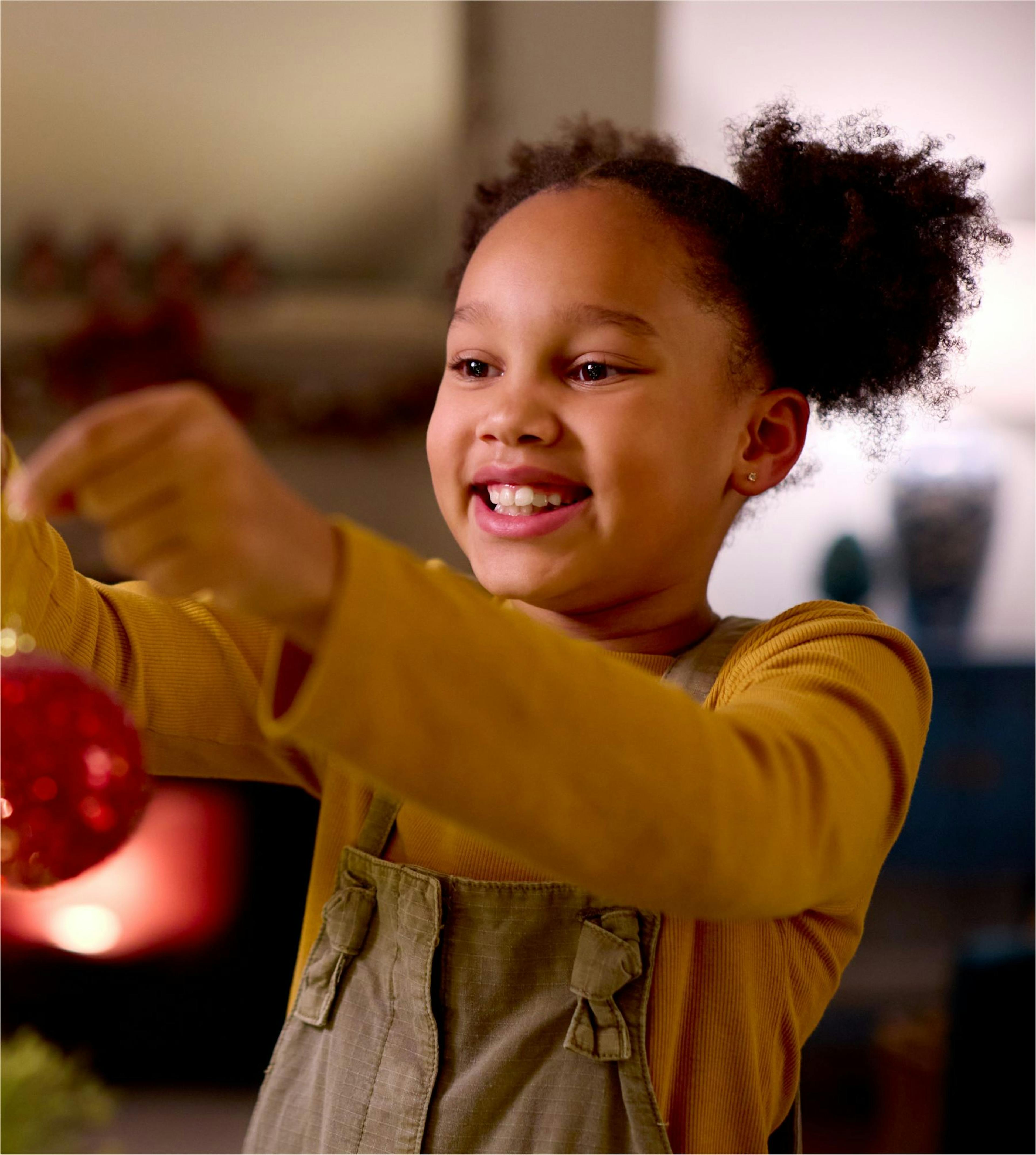 Young girl hanging a Christmas decoration