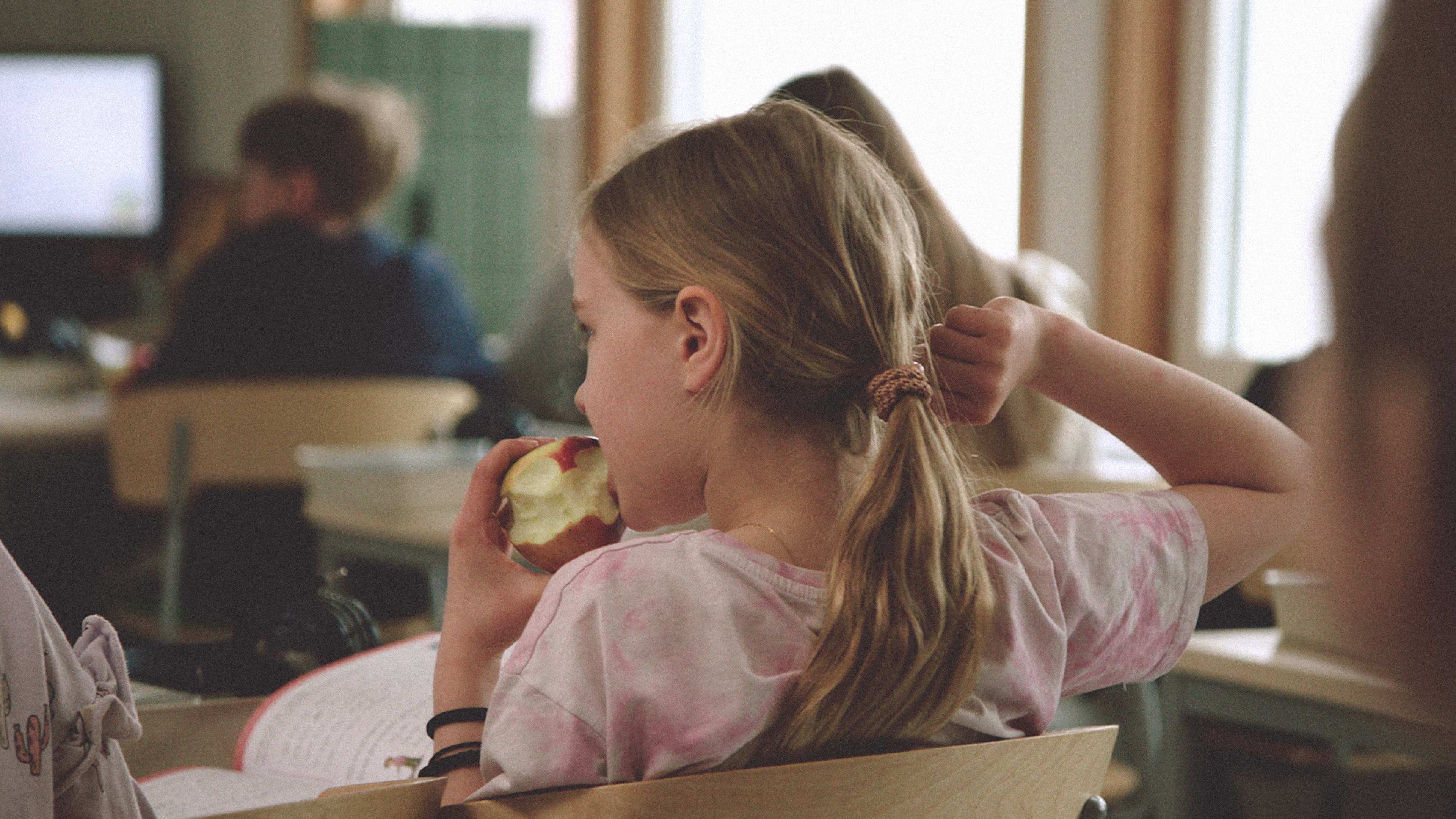 young girl eating an apple