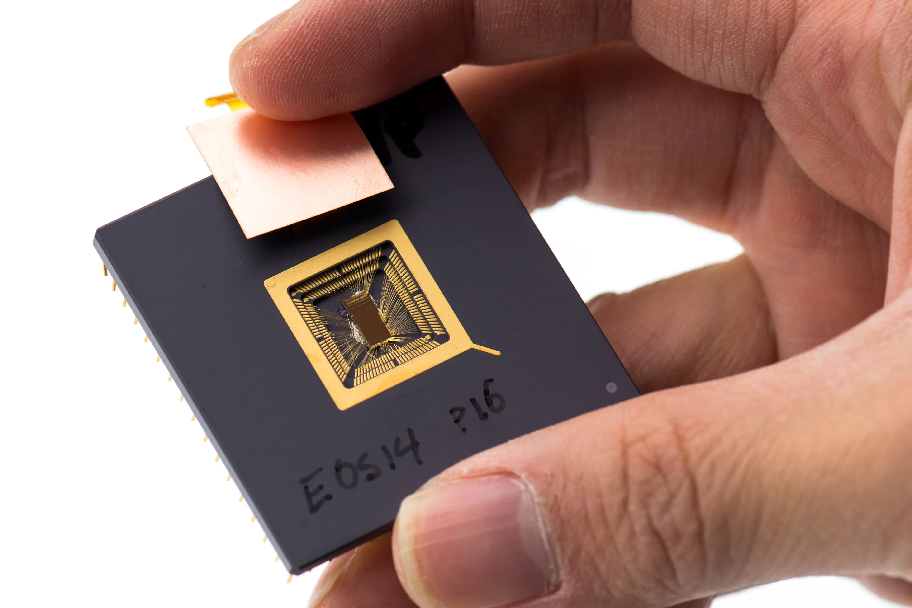 Yunsup Lee holding an early RISC-V prototype chip with its silicon die and gold bond wires exposed