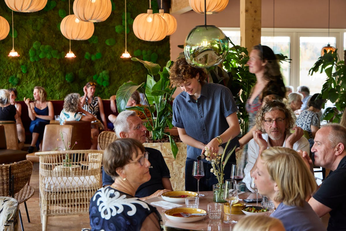 Restaurant met bezoekers Livia schenkend.jpg