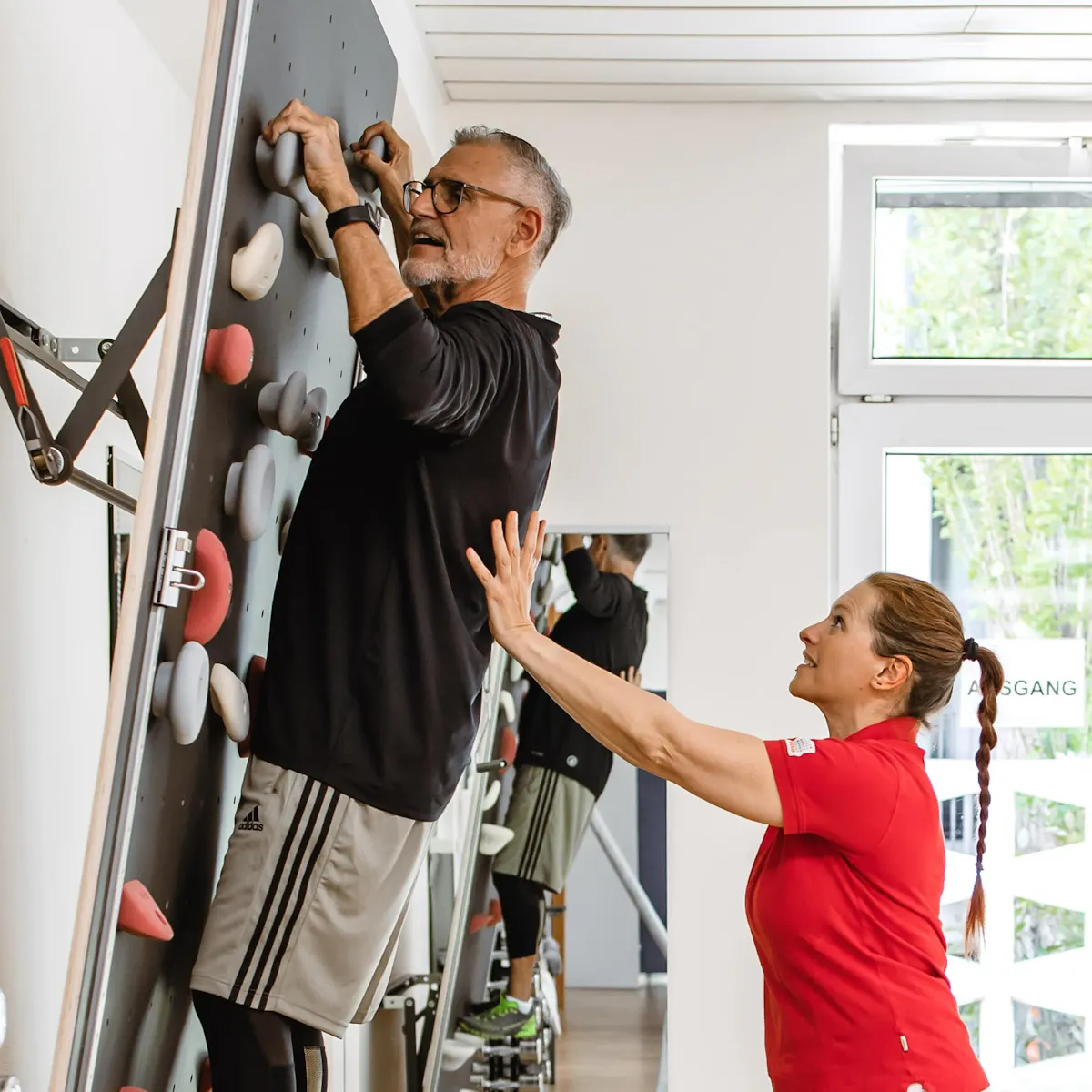 Physiotherapeutin bei einer Übung mit einem Bandscheibenvorfall-Patienten