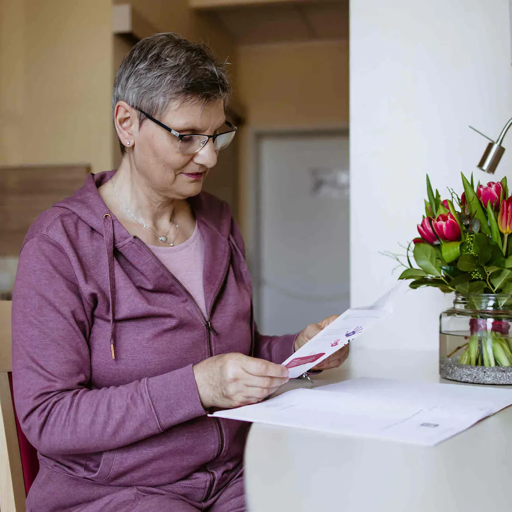 Patientin der Wicker Klinik liest eine Broschüre in ihrem Einzelzimmer