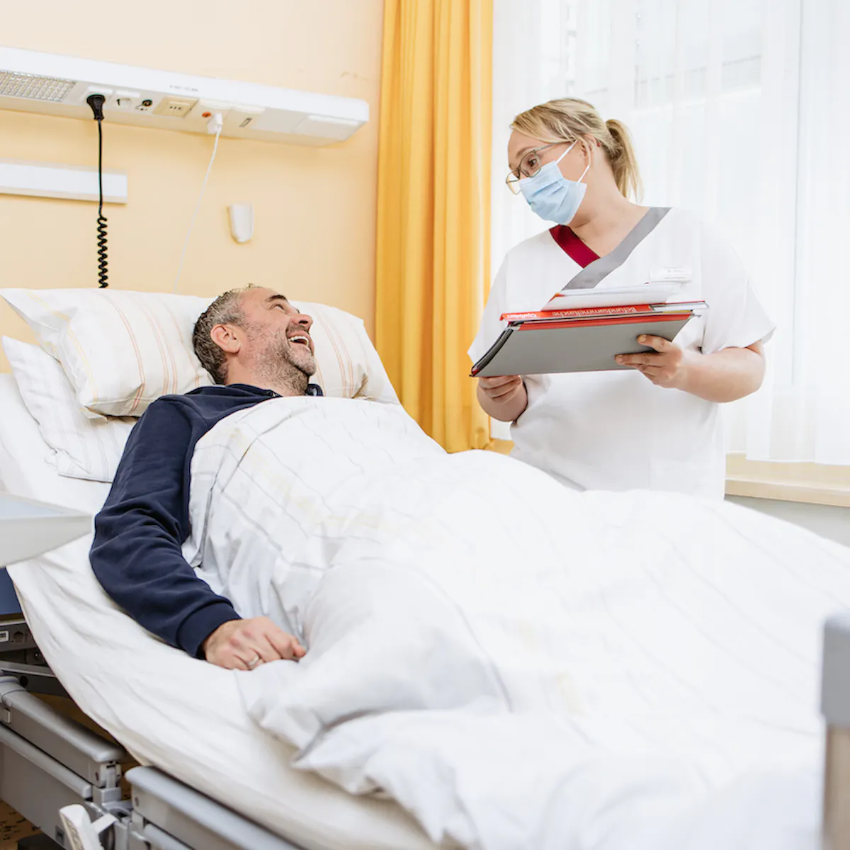 Pflegerin der Werner Wicker Klinik Bad Wildungen steht neben Patienten am Krankenhausbett