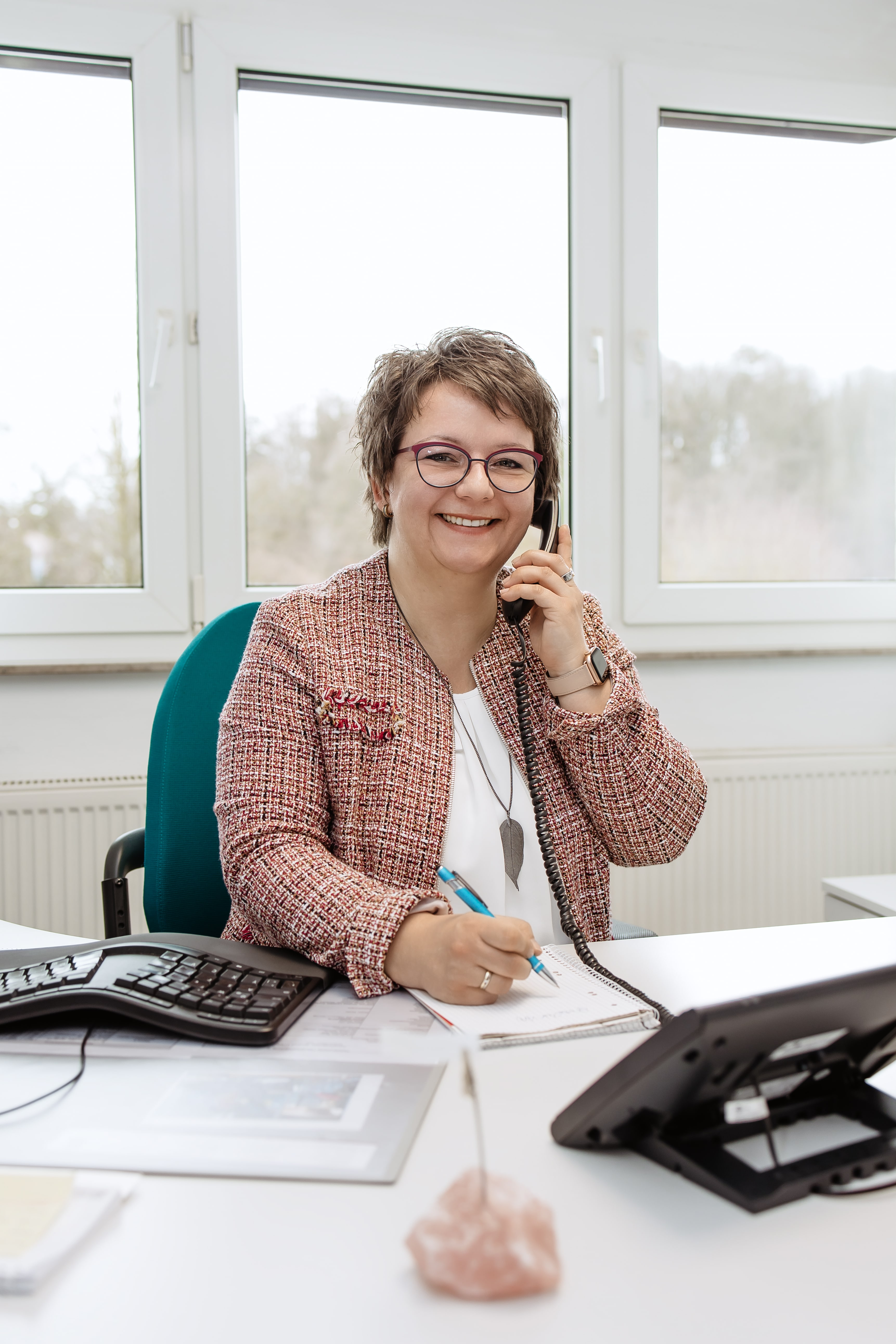 Mitarbeitern der Wicker-Kliniken am Schreibtisch mit Telefonhörer am Ohr