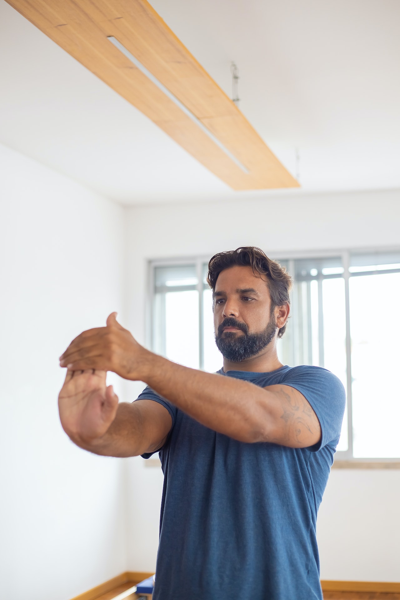 Mann mit rheumatoider Arthritis dehnt sein Handgelenk