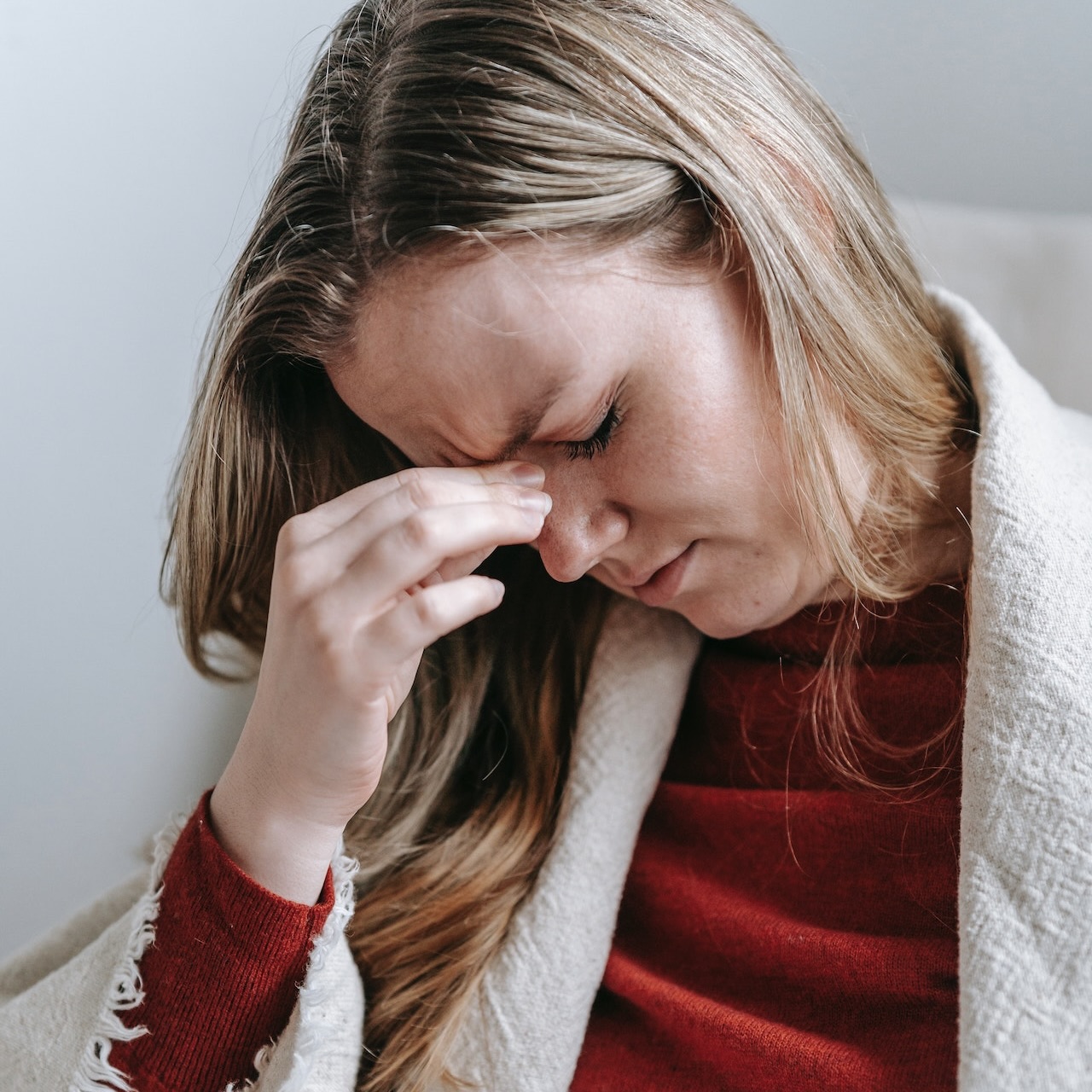 Frau mit Clusterkopfschmerzen fasst sich an den Kopf