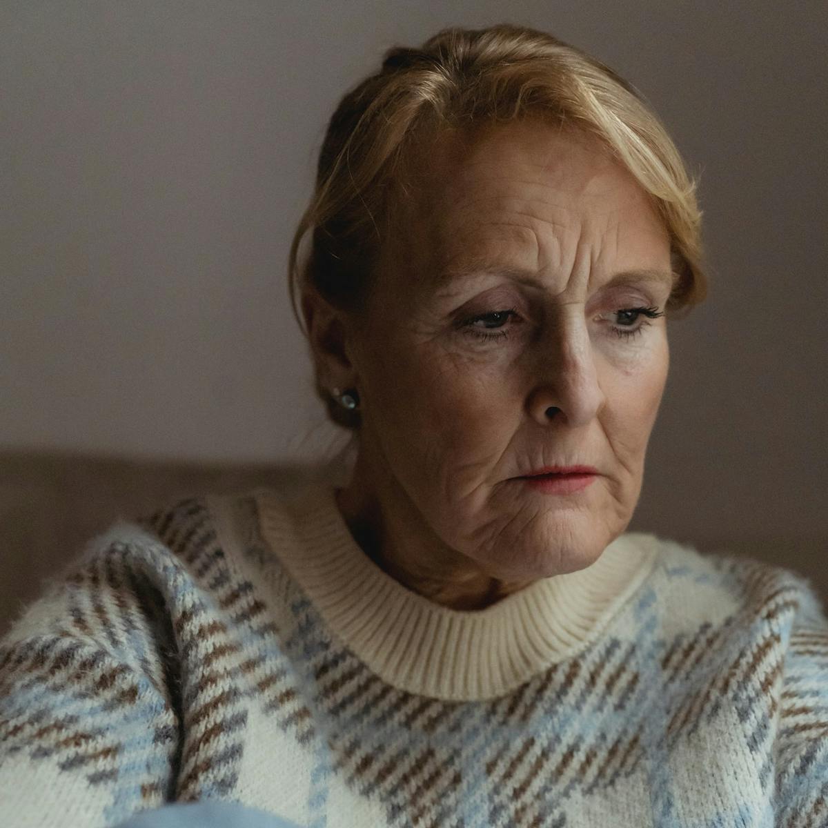 Portraitaufnahme einer älteren traurig schauenden Frau