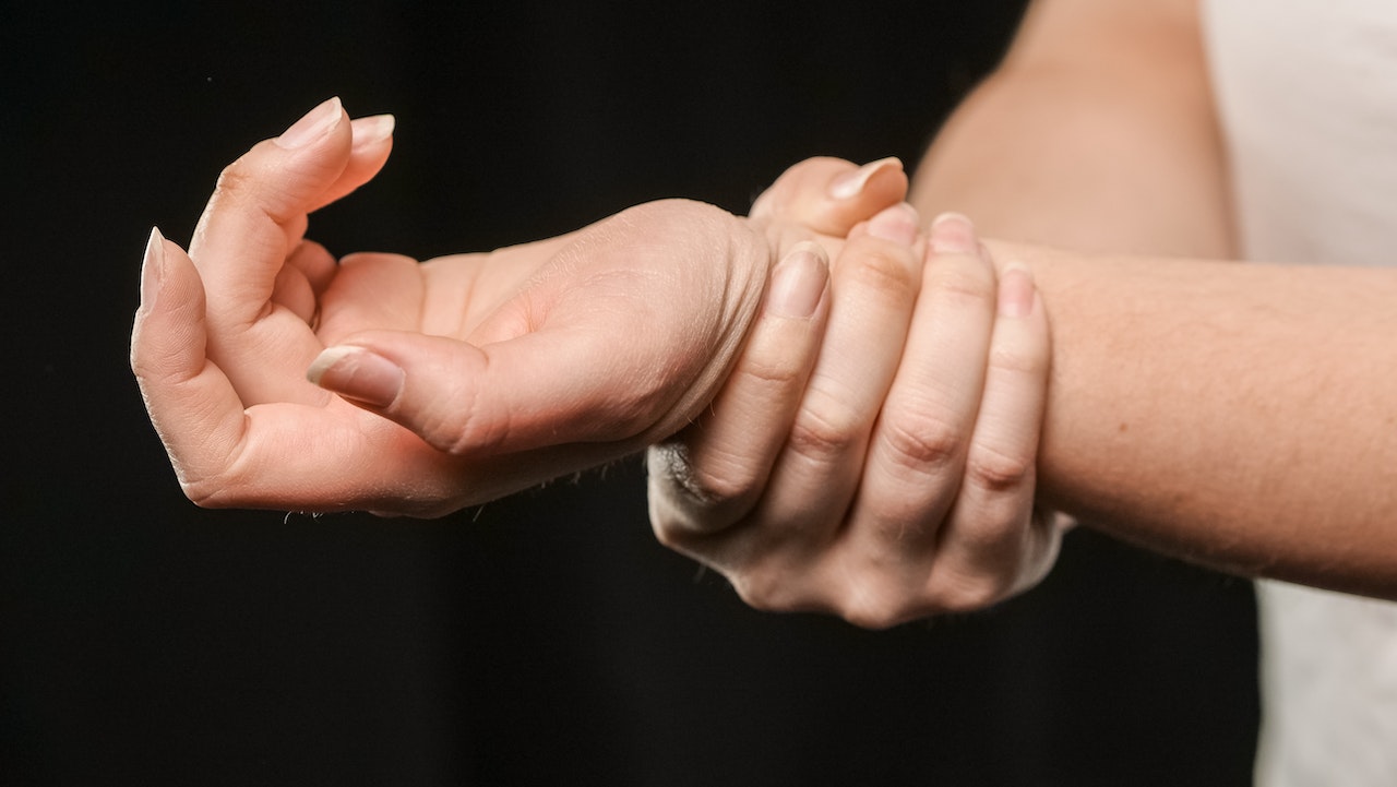 Person umfasst ihr Handgelenk