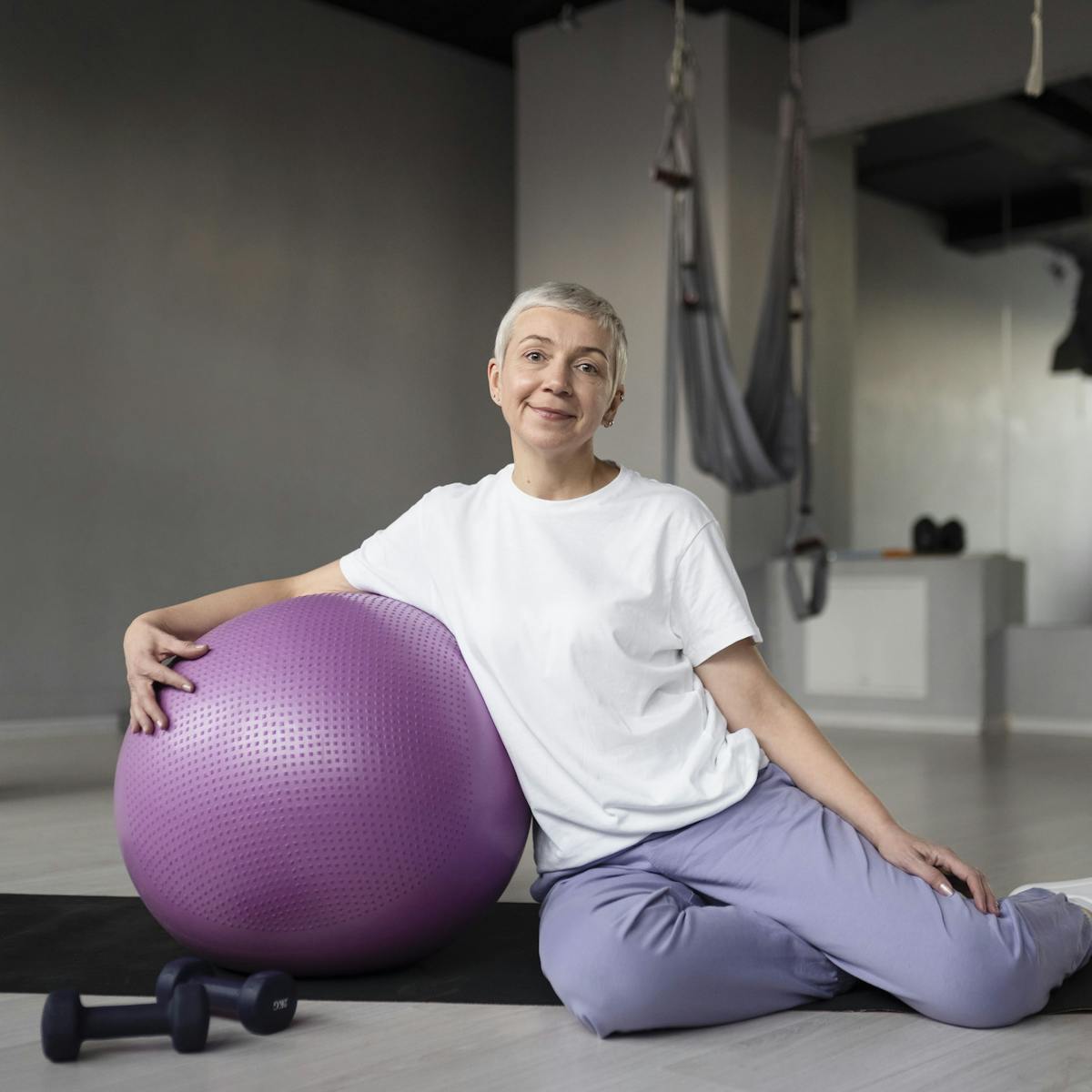Patientin mit Gymnastikball bei der orthopädischen Bewegungstherapie