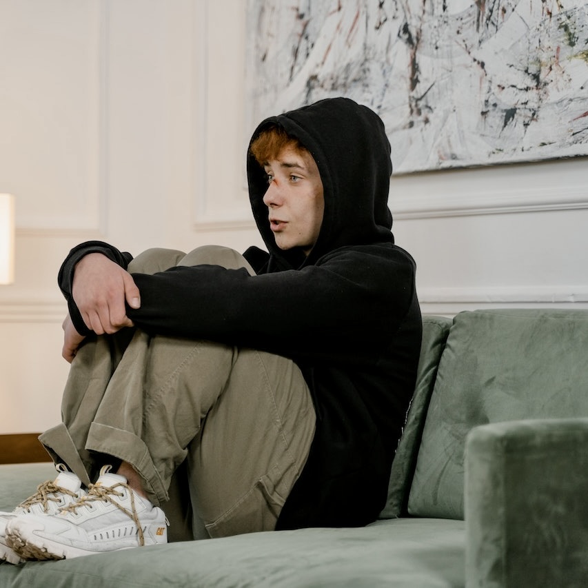 Traumatisierte Person sitzt auf dem Sofa