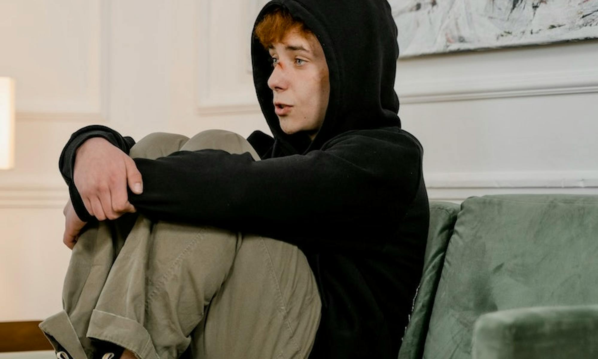 Traumatisierte Person sitzt auf dem Sofa