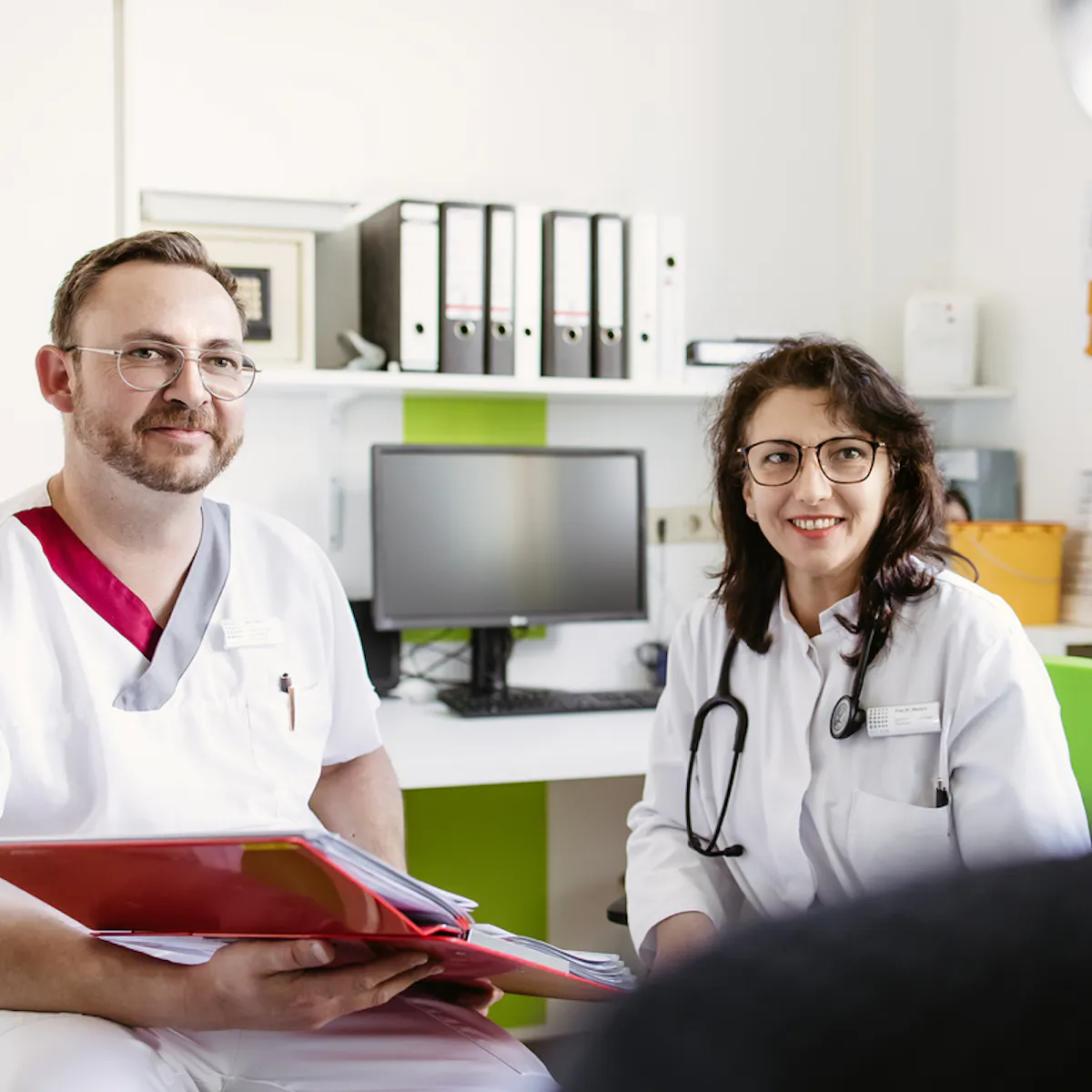 Pfleger und Ärztin im Beratungsgespräch mit einem Patienten