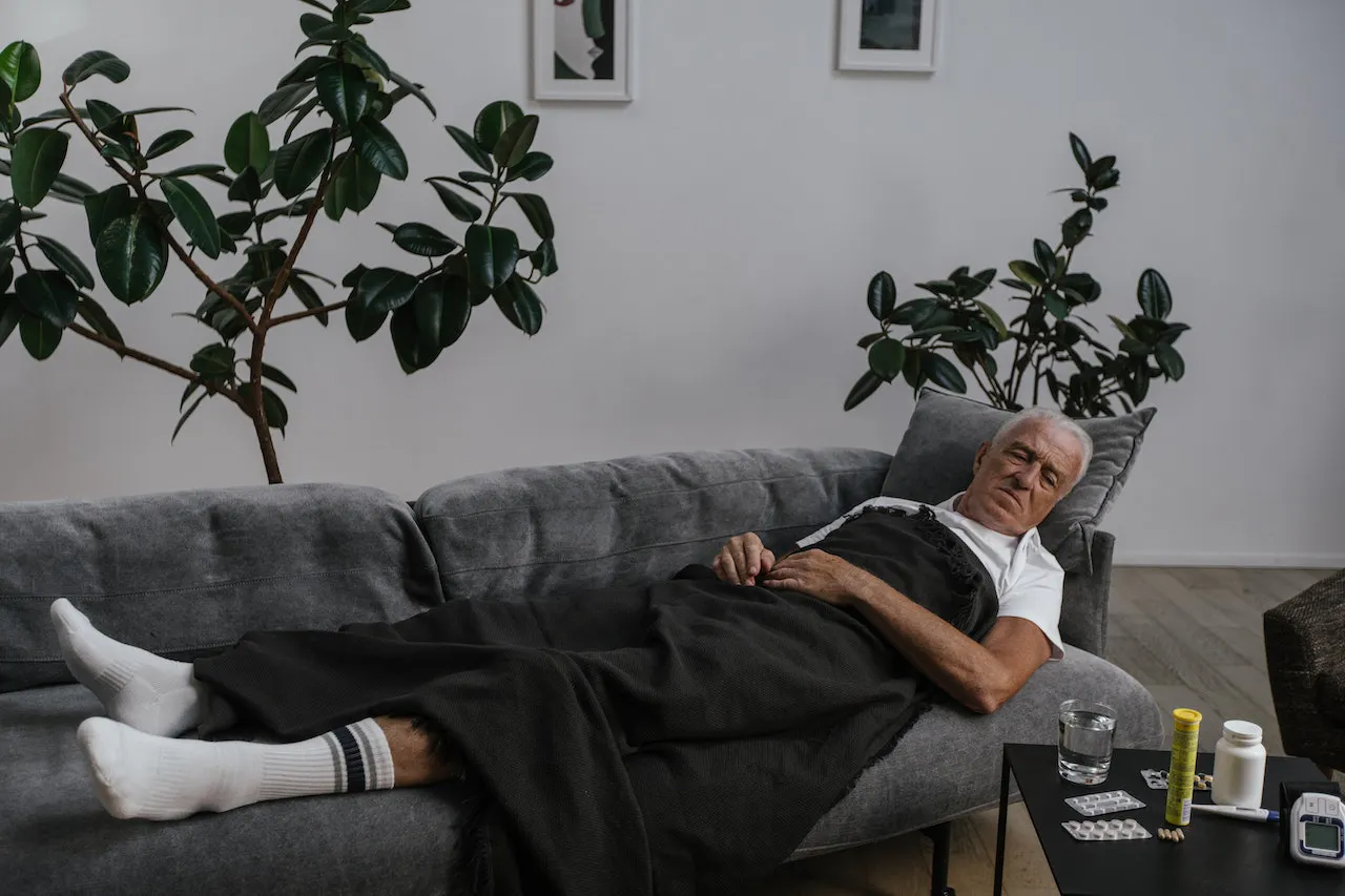 Kranker Mann liegt auf dem Sofa